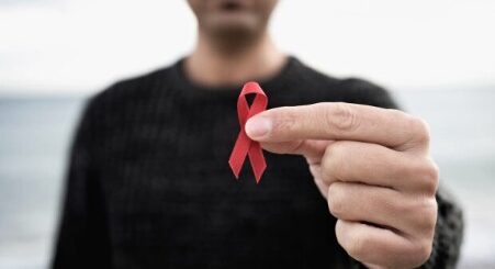 Person holding red ribbon