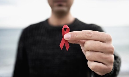 Person holding red ribbon
