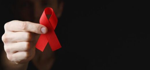 hand holding a red ribbon